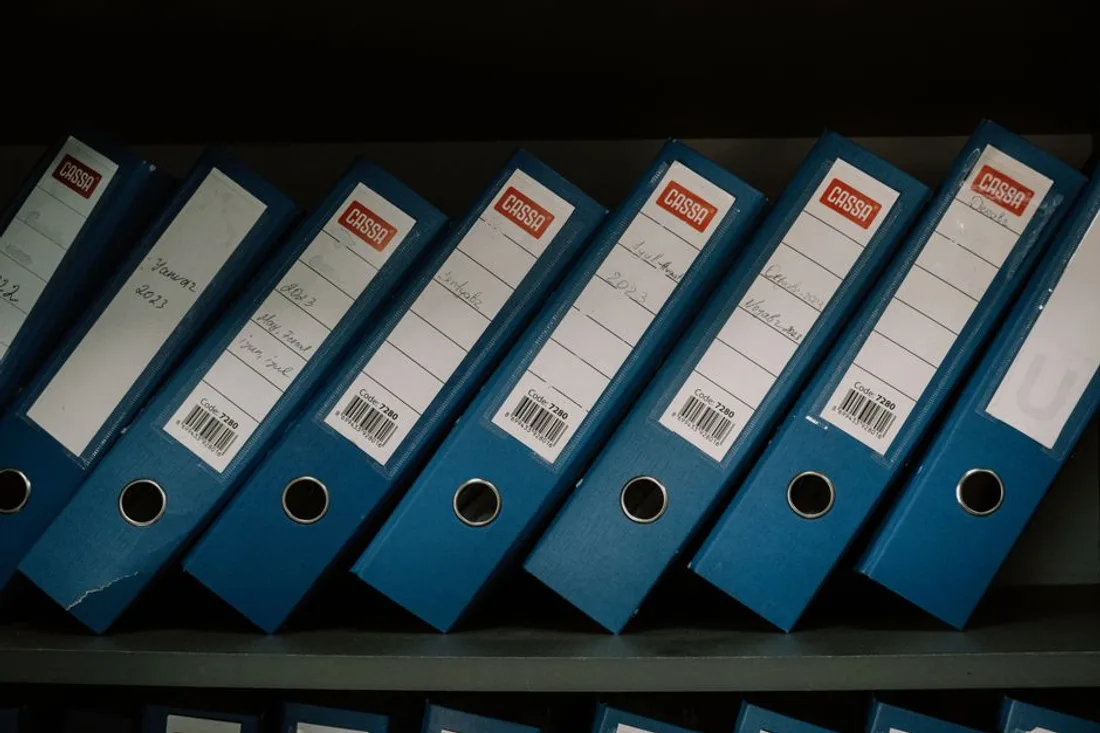 Dicht gefüllte Archivregale mit beschrifteten Ordnern