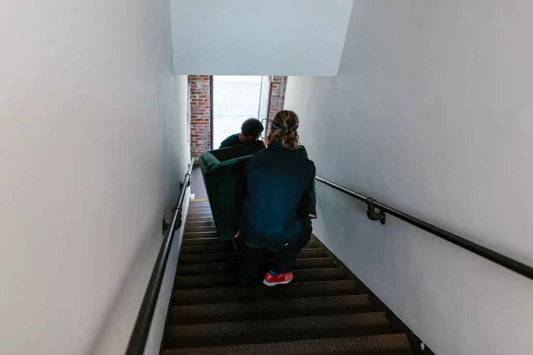 Sofa wird durch ein Treppenhaus getragen