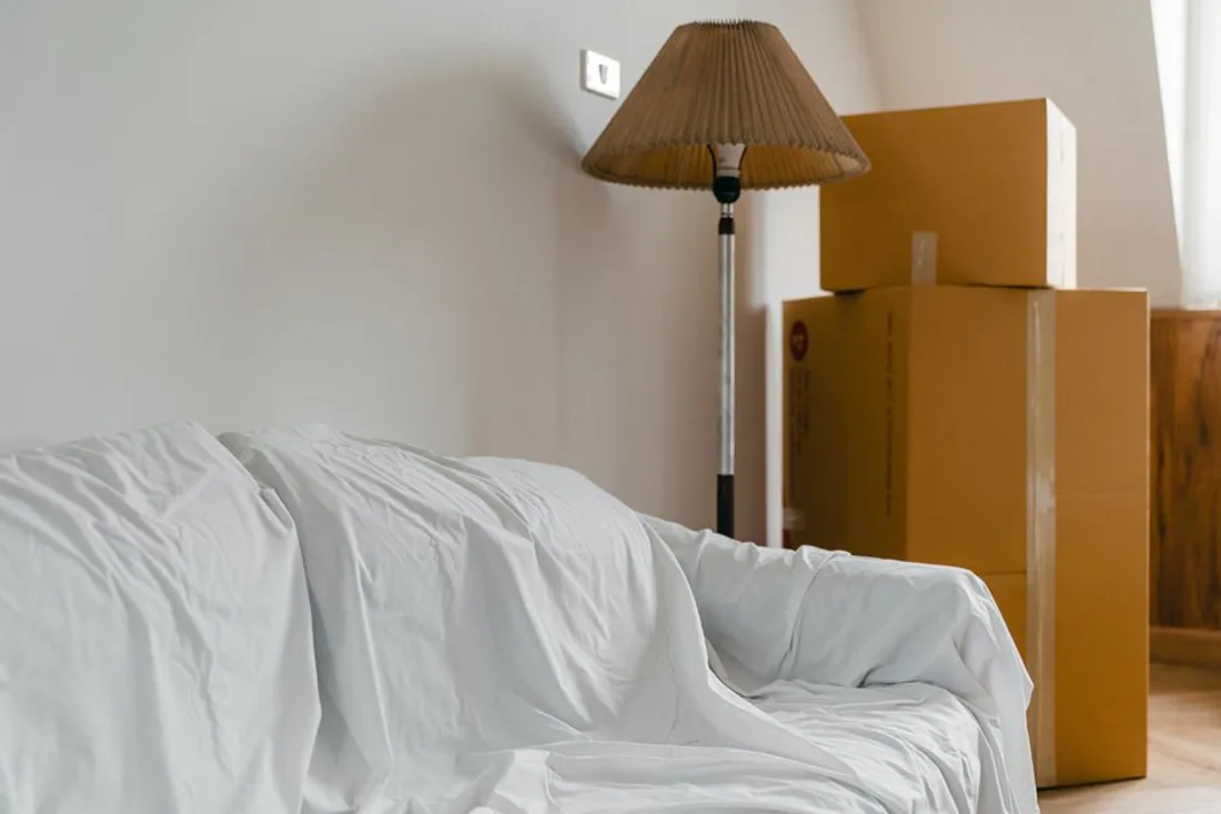 Gepackte und beschriftete Umzugskartons in einer ausgeräumten Wohnung